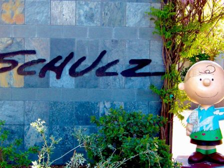 A statue of an animated character stands next to a wall with the name 