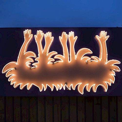 The image shows a sign featuring a glowing outline of cartoonish figures with raised hands and spiky hair, illuminated against a dark background.