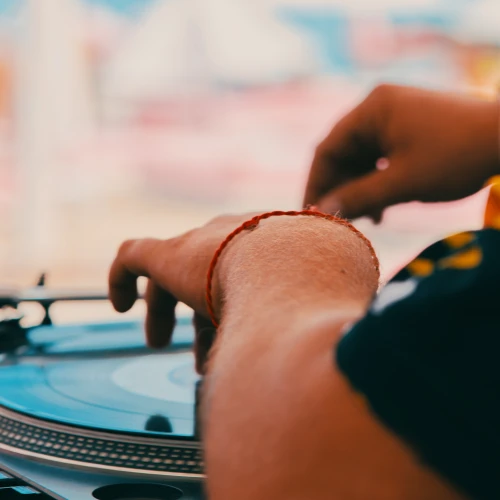 A person is using a turntable, adjusting the vinyl record with their hands.