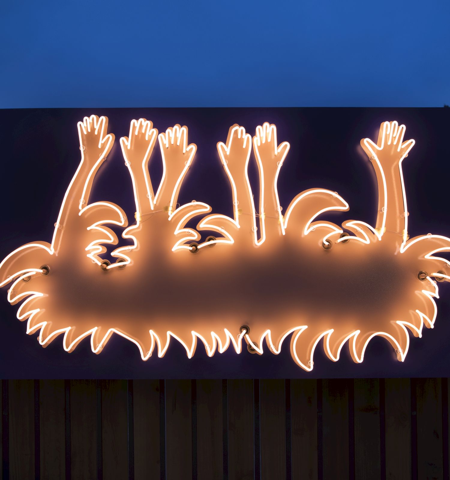 A neon sign shaped like multiple hands raised in greeting or celebration, glowing orange with a jagged edge outline, mounted on a dark panel.